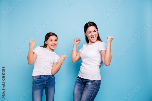 Close up photo cheer pretty two people brown haired mum small little daughter  arms up in air gladly yelling got free sale discount shopping wear white t-shirts isolated bright blue background