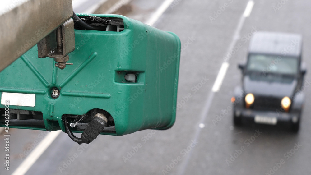 winter day view average speed traffic camera under falling snow over UK Motorway