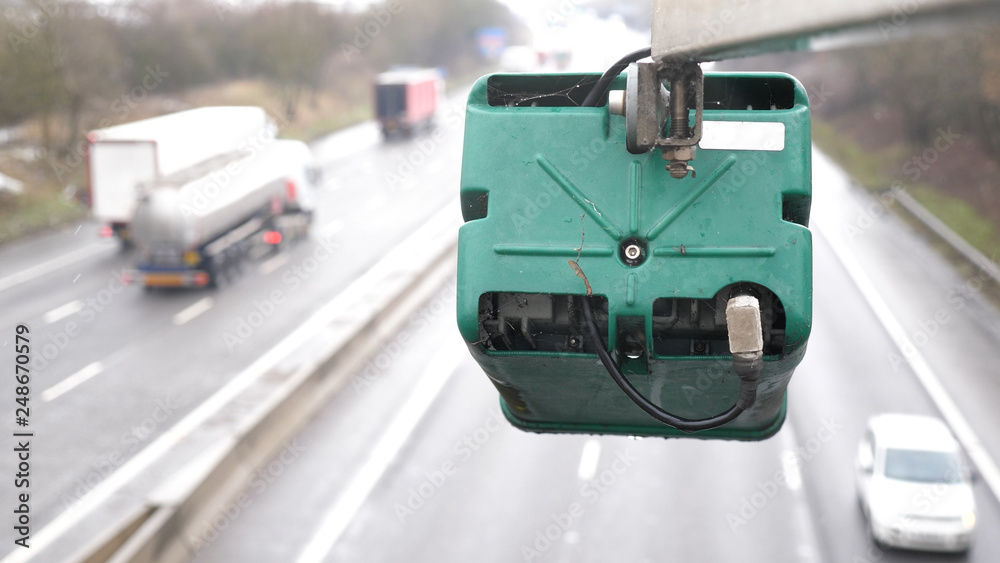 Obraz premium winter day view average speed traffic camera under falling snow over UK Motorway
