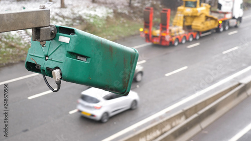 winter day view average speed traffic camera under falling snow over UK Motorway