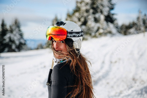 beautiful girl walking on snow helmet on his head