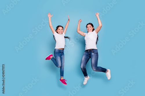 Full length body size view of two nice cute lovely winsome attractive adorable cheerful cheery slim people in white t-shirt raising hands up rejoice isolated over blue pastel background
