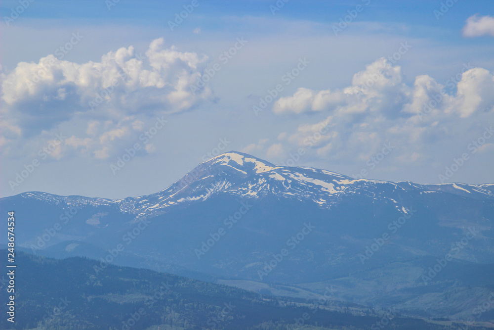 Fototapeta premium Stunning landscape of a gentle morning sunrise on a warm summer morning over the line of the blue Carpathian mountains