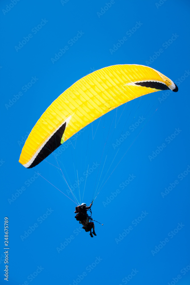 Paraglider Instructor Flying with Customer in Blue Summer Sky