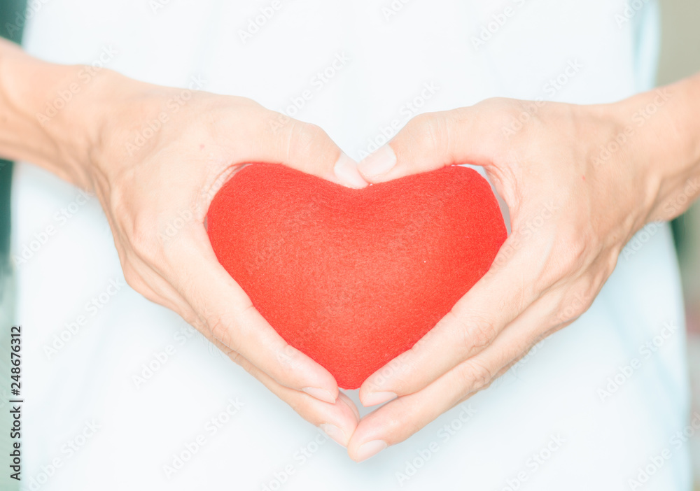 handsome man holding red heart in hands and making heart shape gesture sign body language giving for love life healthy care medicine hospital concept and lovely romantic for valentines day. handsome man holding red heart in hands and making heart shape gesture sign body language giving for love life healthy care medicine hospital concept and lovely romantic for valentines day.