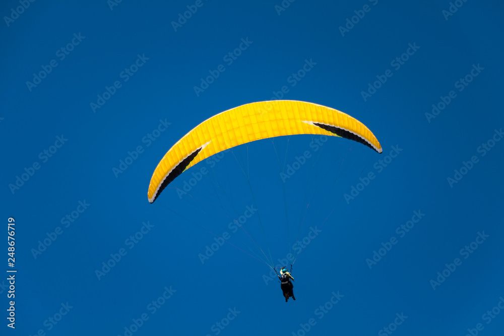 Paraglider Instructor Flying with Customer in Blue Summer Sky Paraglider Instructor Flying with Customer in Blue Summer Sky