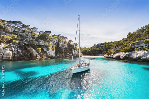 Piękna plaża z żaglówką, Cala Macarelleta, wyspa Menorca, Hiszpania. Koncepcja żeglarstwa, podróży i aktywnego stylu życia