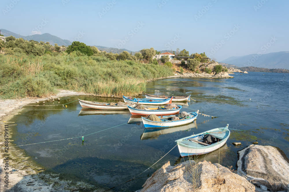 Fishing boats moored along the shore of Lake Bafa in Turkey.