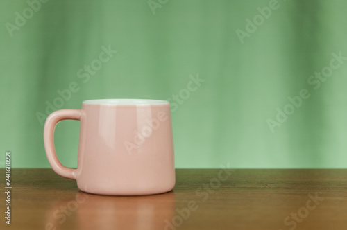 pink coffee cup on old wooden table