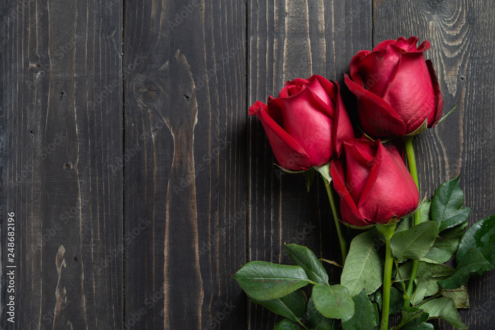 Bouquet of red rose flower on dark wooden table. Can use for valentine day concept or background.