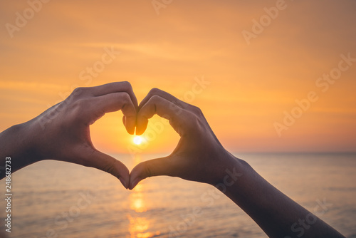 Female hands in the form of heart against sunlight in sunset sky  twilight time. Hands in shape of love heart  Love concept.