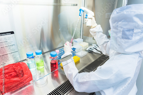 A scientist in sterile coverall gown Doing biological research in clean environmental. Cleanroom facility