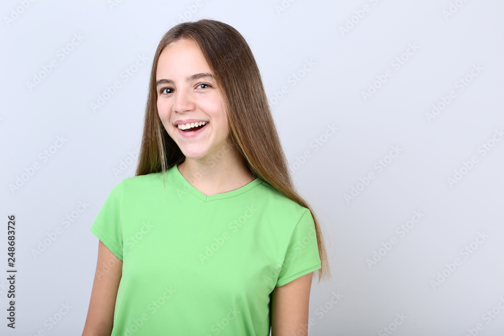 Young girl wearing t-shirt on grey background Young girl wearing t-shirt on grey background