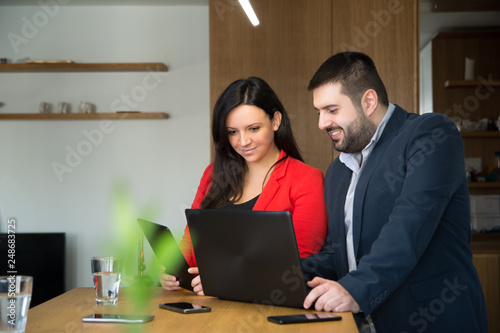 Two young business colleagues working on laptop