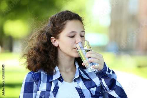 Young girl drinking water in the park