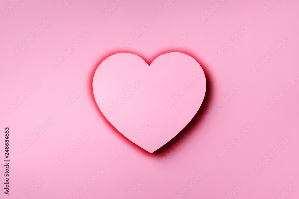 Pink heart cutted from paper over punchy pastel background with copy space. Top view. Valentine's Day. Love, date, romantic concept.