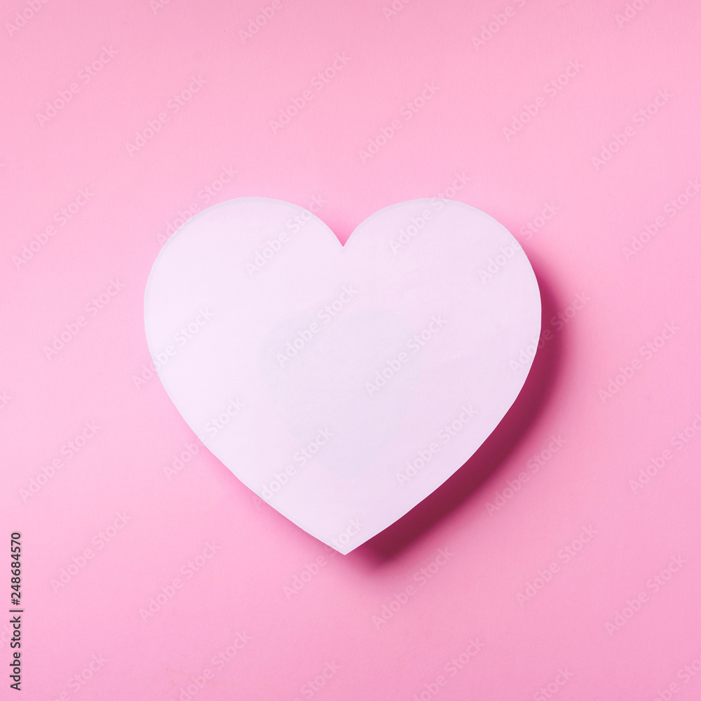 White heart cutted from paper over punchy pastel background with copy space. Top view. Valentine's Day. Love, date, romantic concept. Square crop.