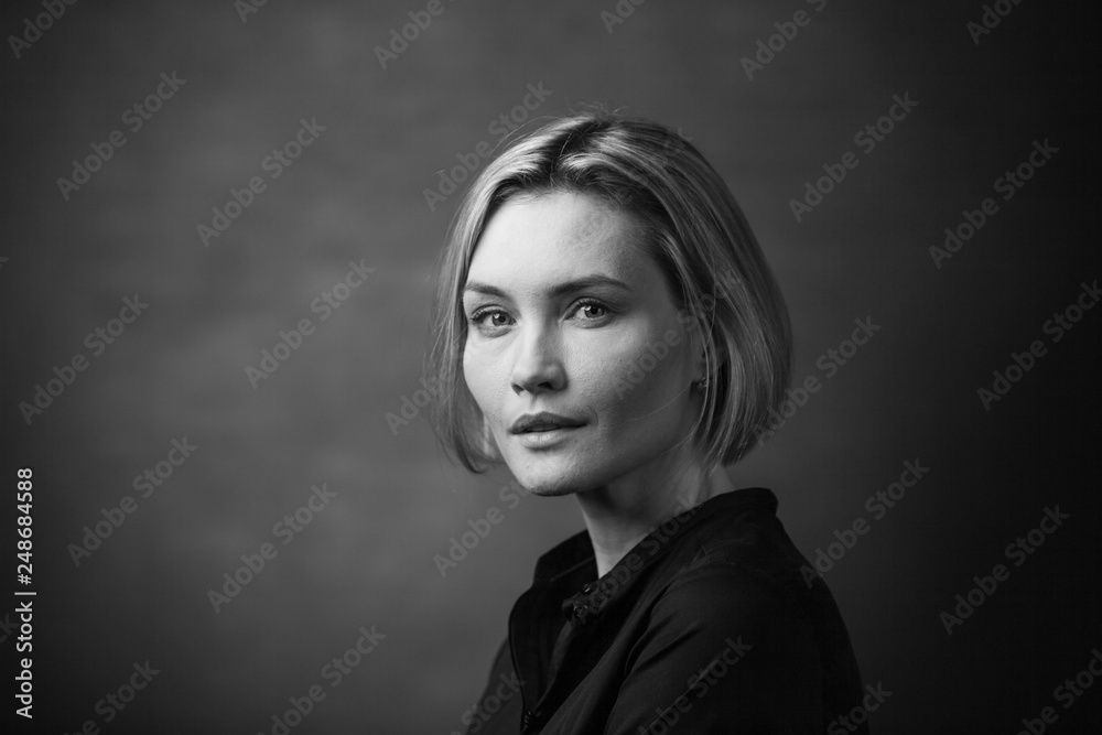 Fototapeta premium Dramatic black and white portrait of a beautiful woman on a dark background