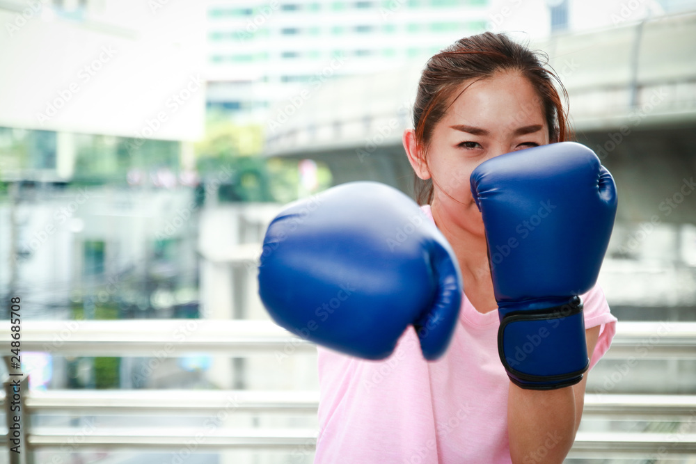 Asian women Exercise punch Put the blue glove at the punch.