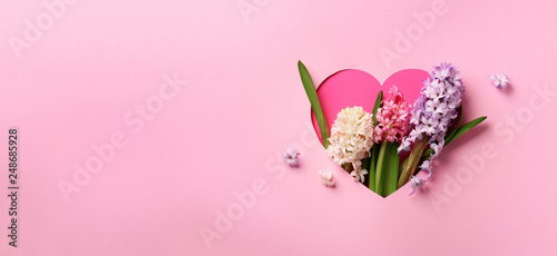 Fényképezés Hyacinth flowers in hole in heart shaped form over pink punchy pastel background