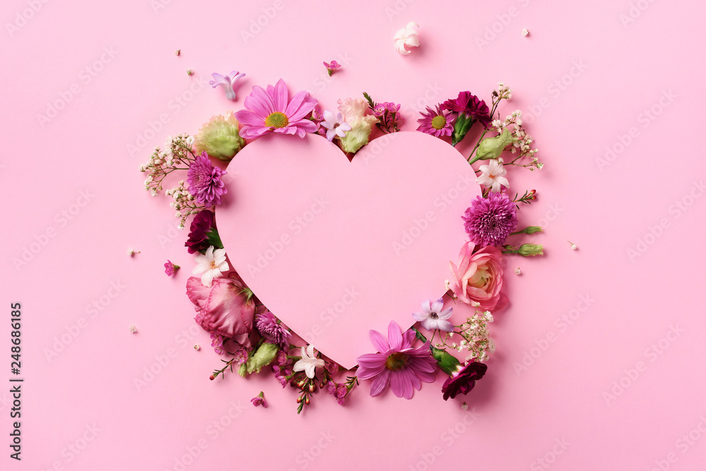 Creative layout with pink flowers, paper heart over punchy pastel background. Top view, flat lay. Spring, summer or garden concept. Present for Woman day - obrazy, fototapety, plakaty 