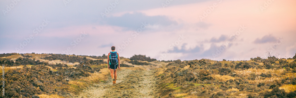 Hike trail hiker walking alone on desert landscape on trek adventure banner panorama. Nature travel wanderlust man person traveler.