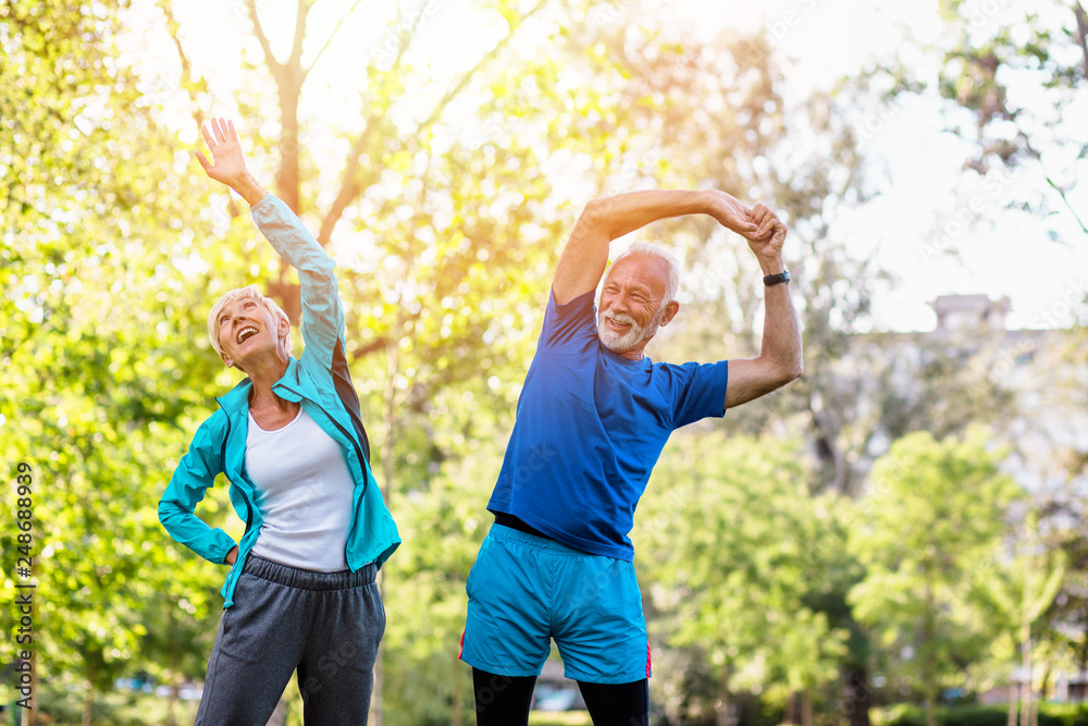 Obraz premium Happy fit senior couple exercising in park.
