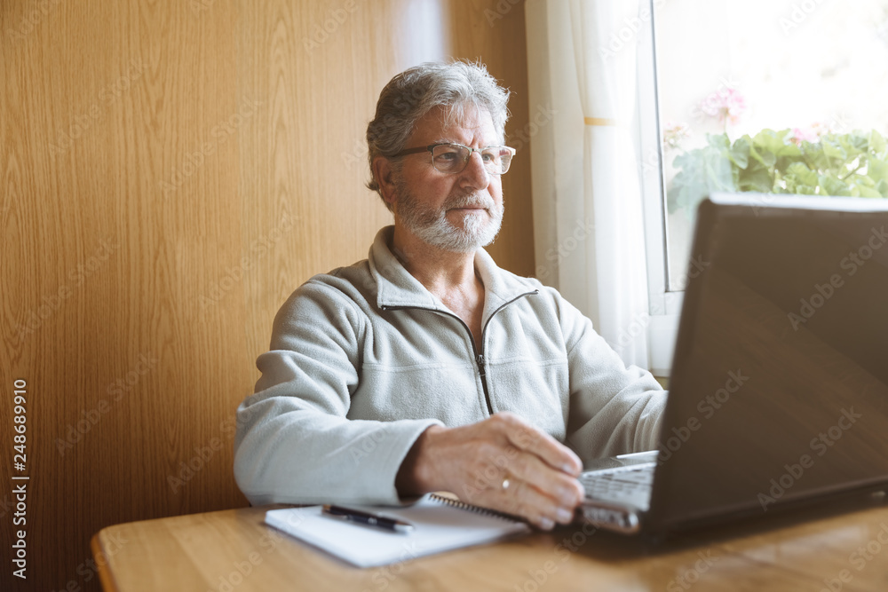 Senior man working with his laptop at home Senior man working with his laptop at home