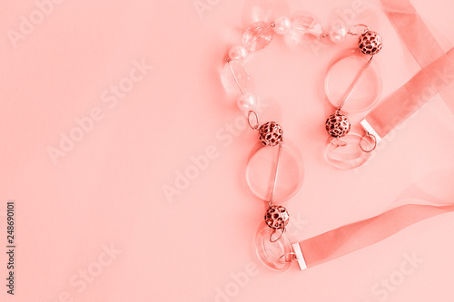 Female coral beads on a pink background. Empty space for text