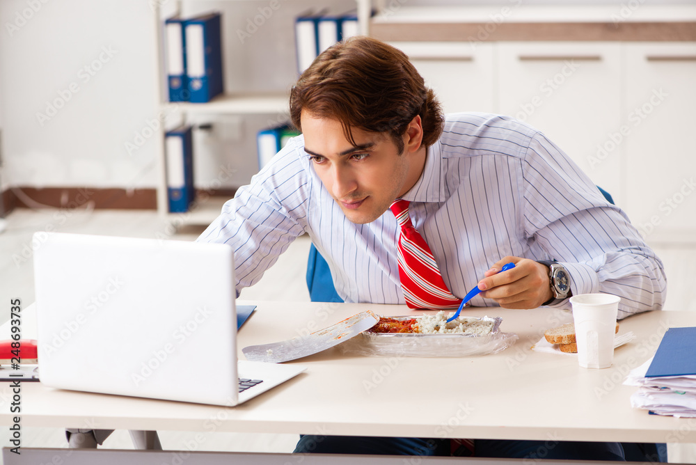 Man having meal at work during break Man having meal at work during break