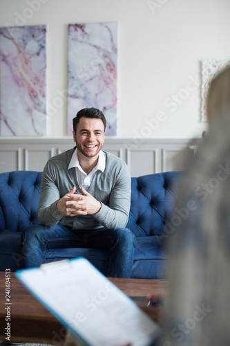 Happy smiling man at the reception at the psychologist.