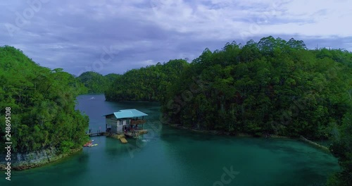 Aerial view flying over the beautiful and tropical green mountains Sugba Lagoon in Siargao, Philippines