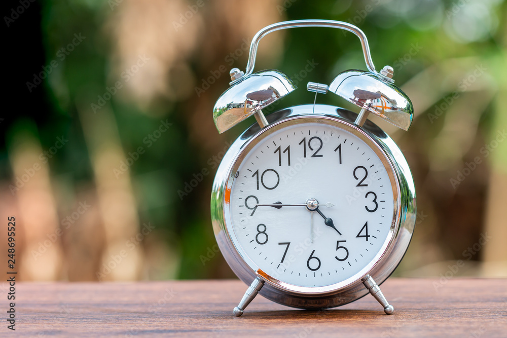Retro alarm clock on wood table with bokeh background Retro alarm clock on wood table with bokeh background