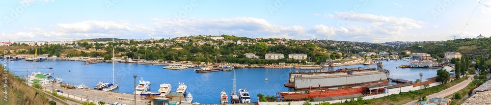 Panorama of Yuzhnaya bay in Sevastopol, Ships of the Black Sea Fleet of Russia and view to the factory and the city.