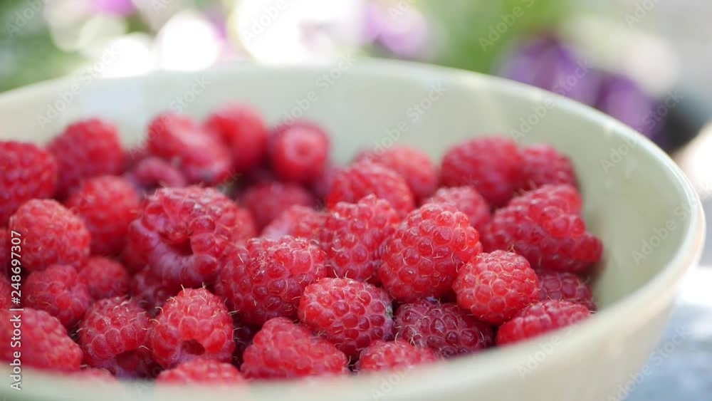A lot of fresh raspberries in rotating bowl. Closeup A lot of fresh raspberries in rotating bowl. Closeup