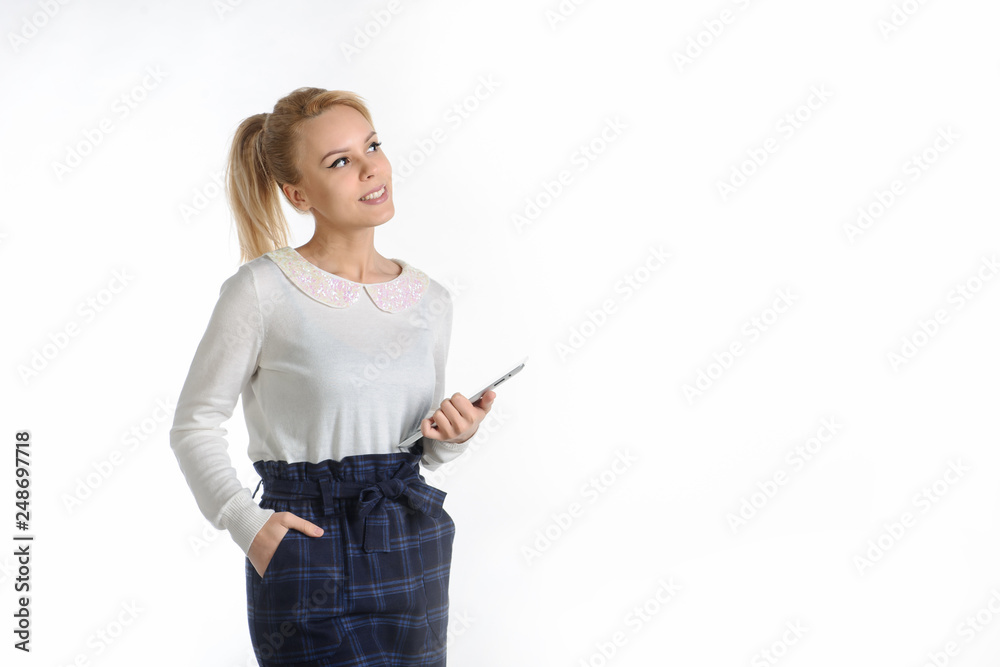 20-years blond girl in white blouse and blue skirt on white background talking with a tablet in her hands 20-years blond girl in white blouse and blue skirt on white background talking with a tablet in her hands