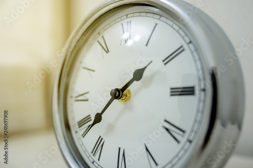 a silver vintage clock on the nighstand