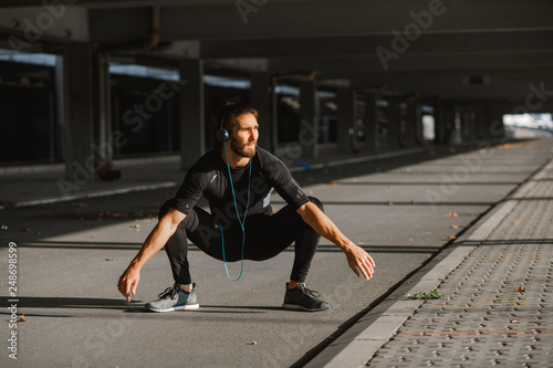 Young sports man stretching outdoors