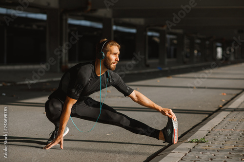 Young sports man stretching outdoors