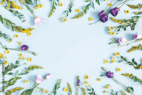 Flowers composition. Yellow and purple flowers on pastel blue background. Spring, easter concept. Flat lay, top view, copy space