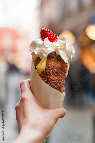 Woman holds in hand Trdlo or Trdelnik, it is a national street street food of Prague