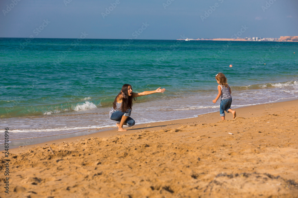Mother and daughter playing on the beach