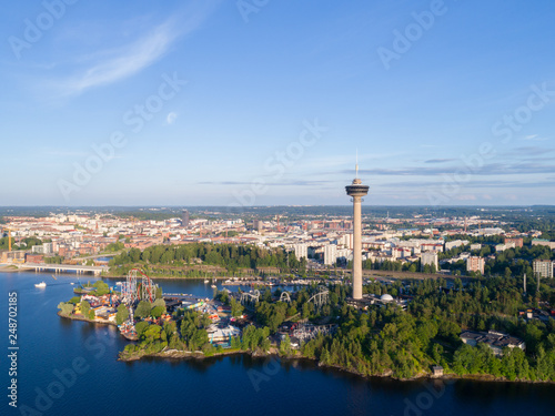 Aerial view from the lake. Observation tower and amusement park on the shore.