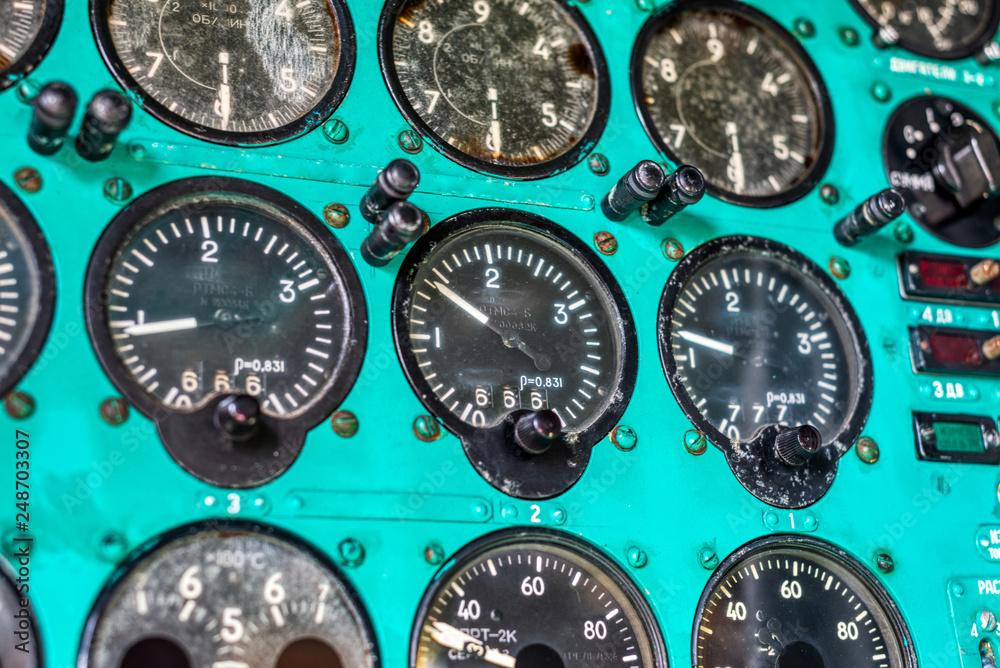 Dashboard of an old airplane. Many analog pointers, buttons and switches Dashboard of an old airplane. Many analog pointers, buttons and switches