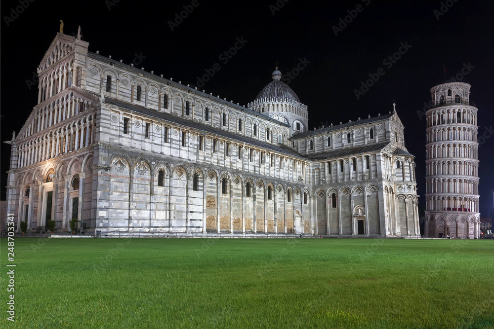 Night scene with Leaning Tower of Pisa and 11th century Roman Catholic cathedral, Italy. Historic Piazza dei Miracoli, UNESCO World Heritage Site