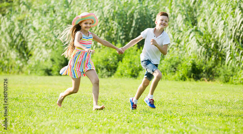 two happy children active playing and running outdoors