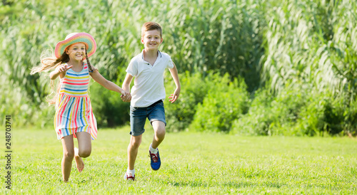 two enthusiastic children active playing and running outdoors