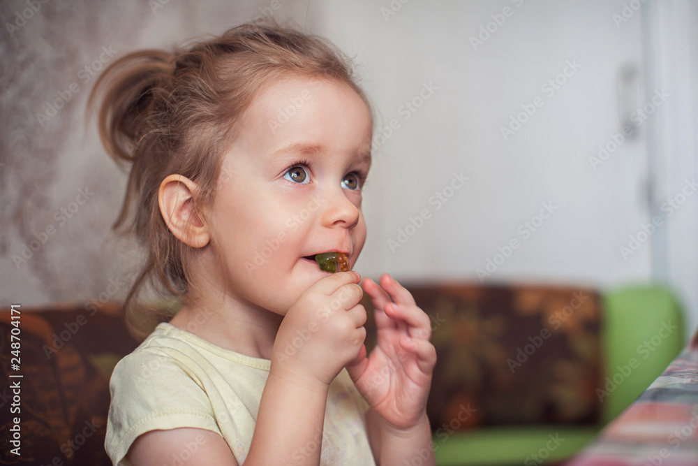 Little funny girl eats marmalade closeup portrait Little funny girl eats marmalade closeup portrait