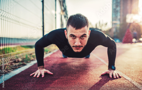 It's time for exercise. Young sportsman doing push ups. Sport, fitness, street workout concept