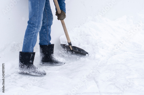 Man cleans the ice rink with a big snow shovel
